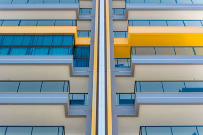 Bottom view of a modern residential building with large balconies. 