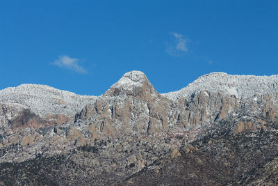 Low angle view of mountain against blue sky