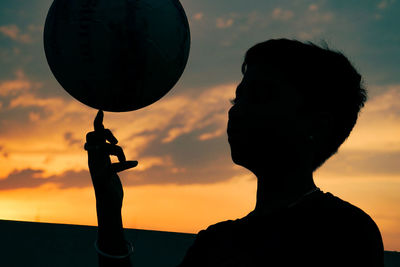 Portrait of silhouette man holding woman against sky during sunset