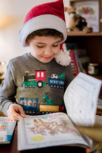 Young boy looking happily at book on christmas day