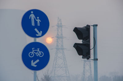 Road sign against the sun