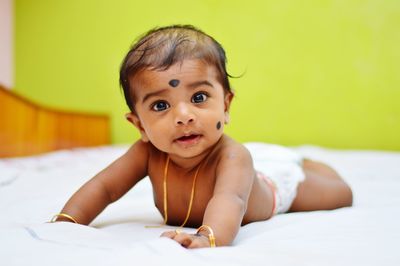 Portrait of cute baby girl on bed