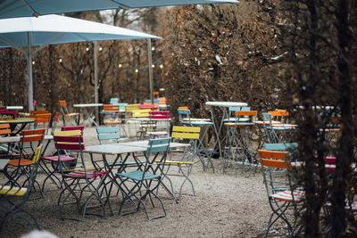 Empty chairs and tables at sidewalk cafe