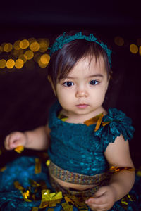 Girl in blue dress in studio with gold sequins and garland