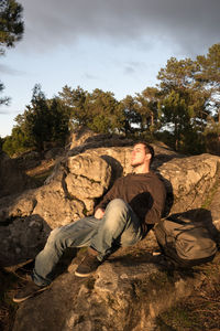 Man lying on the forest rocks at golden hour