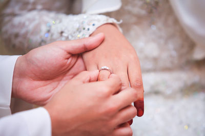 Low section of couple holding hands