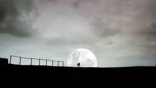 People against cloudy sky