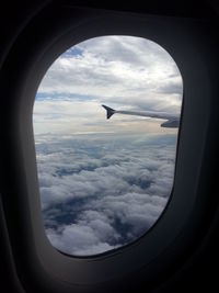 Aerial view of cloudscape seen through airplane window