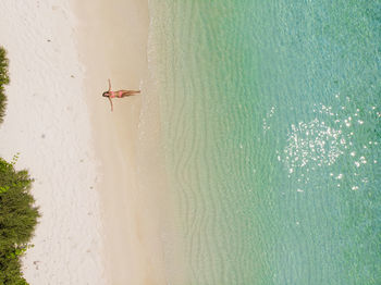 Person paragliding over sea seen through airplane window