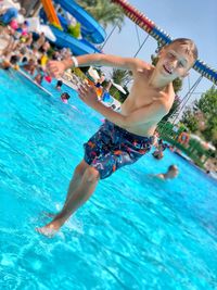 Boy with eyes closed walking in swimming pool