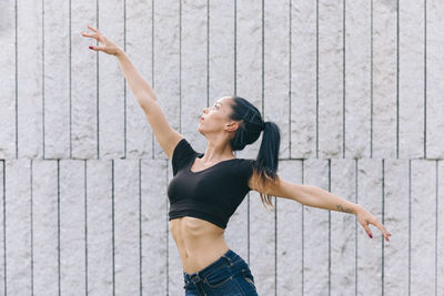 Full length of woman standing against wall