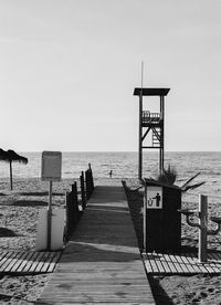 Man running on the beach with watch tower in front 