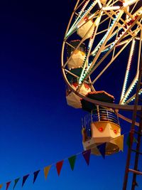 Low angle view of ferris wheel against clear blue sky