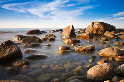 Rocks in sea against sky