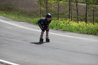 Full length of man riding skateboarding on road