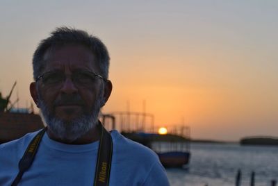 Close-up of man against sea during sunset