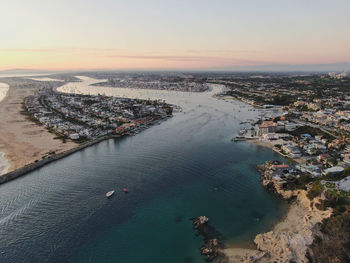 High angle view of sea and buildings against sky during sunset