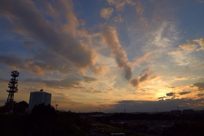 Silhouette of built structures against dramatic sky