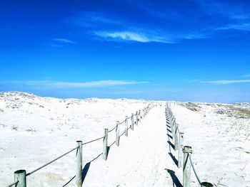 Scenic view of snowcapped mountains against blue sky