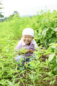 Portrait of smiling boy sitting on field