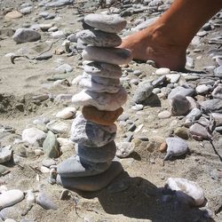 Low section of man on pebbles at beach