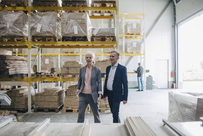 Business people walking by wooden planks at industry