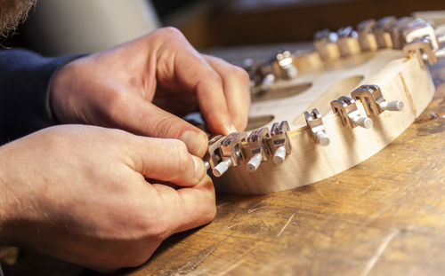 Close up of expert hands while building a part of a violin