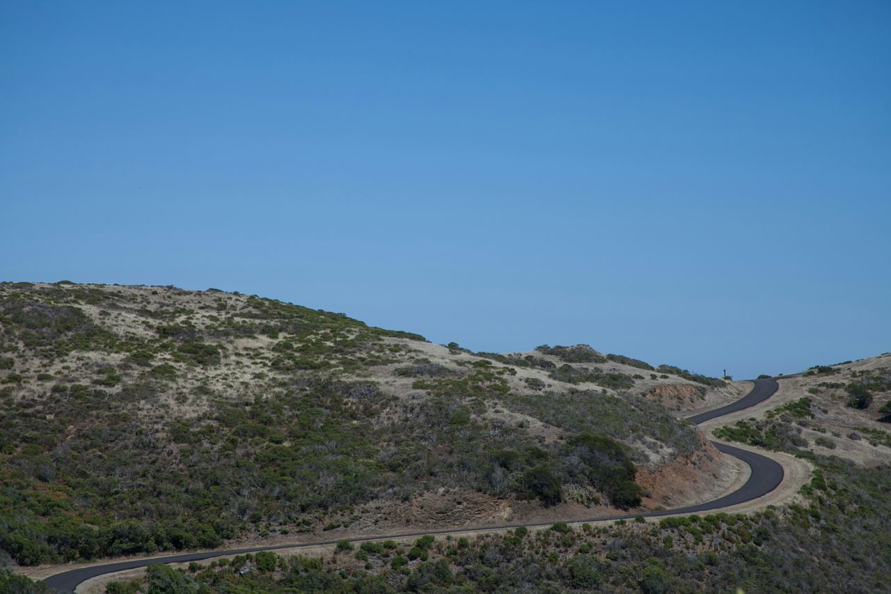 clear sky, copy space, blue, tranquility, tranquil scene, landscape, scenics, mountain, beauty in nature, nature, non-urban scene, day, remote, outdoors, idyllic, tree, rock - object, no people, hill, high angle view