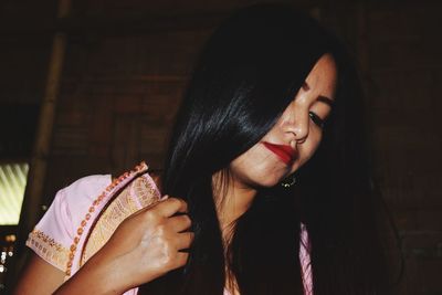 Woman wearing lipstick in darkroom