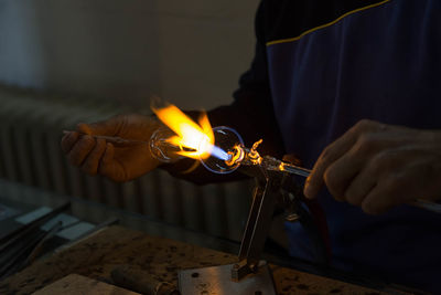 Close-up of hands making glass in factory