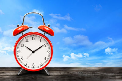 Low angle view of clock against blue sky