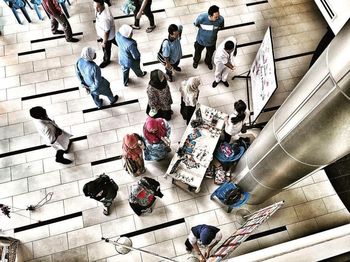 High angle view of people sitting on tiled floor