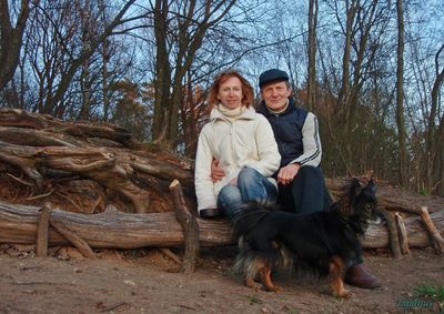 Portrait of smiling man with dog sitting in winter