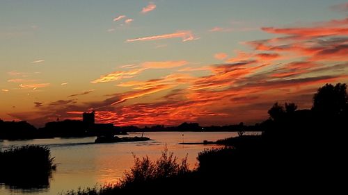 Scenic view of lake against romantic sky at sunset