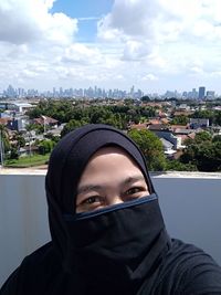 Portrait of young woman against cityscape