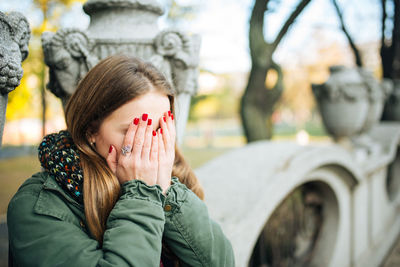 Close-up of young woman covering face