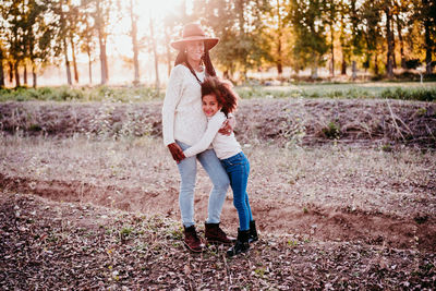 Rear view of mother and daughter standing outdoors