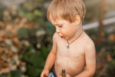 Full length of shirtless boy looking at camera