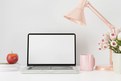 Low angle view of laptop on table against white background