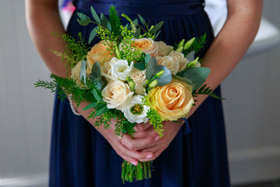 Midsection of woman holding rose bouquet