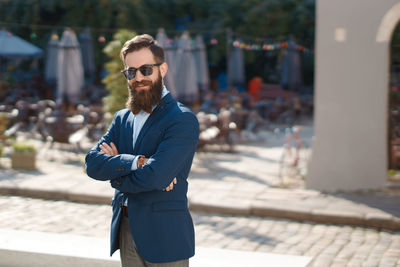 Portrait of young man standing in city