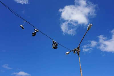 Low angle view of telephone pole against blue sky
