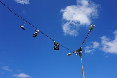 Low angle view of telephone pole against blue sky