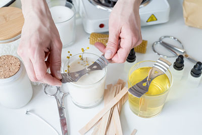 High angle view of hand holding container on table