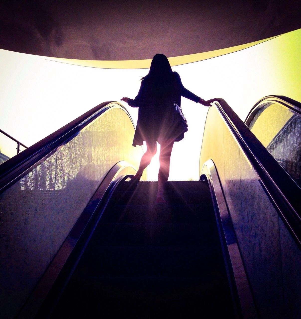 LOW ANGLE VIEW OF PEOPLE ON ESCALATOR AT SUNNY DAY