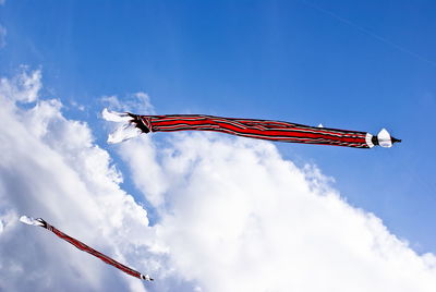 Low angle view of flag flying against sky