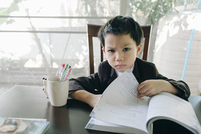 Portrait of boy sitting on table