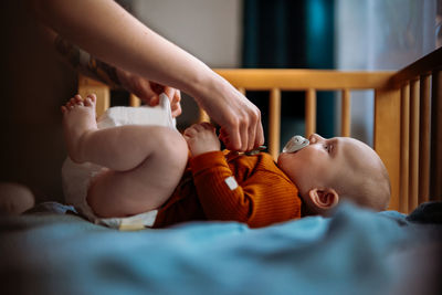 Cute baby with mouthpiece in crib