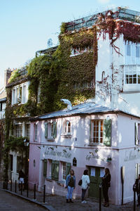 People walking on house against sky