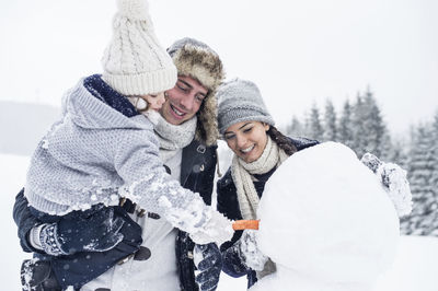 Family building snowman together